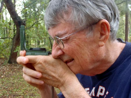 Photograph showing a soldier sighting through a lensatic compass using compass-to-cheek method