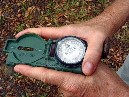 Photograph showing a soldier using the two-hand center-hold technique with a lensatic compass